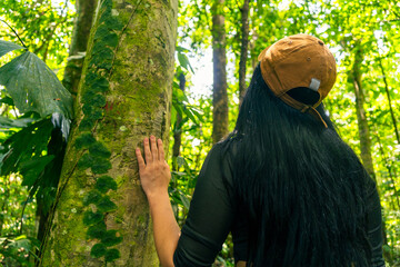 Woman walking in the middle of the lush Amazon rainforest in Latin America.