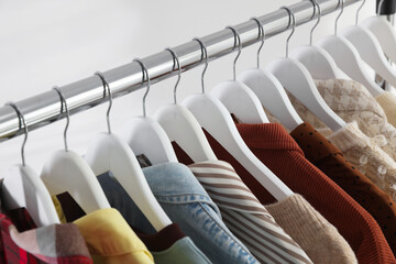 Fototapeta premium Different stylish clothes hanging on rack indoors, closeup