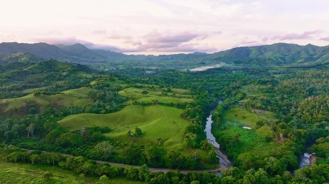 A drone view of a river flowing through a mountain valley early in the morning. Natural landscape of a river stream. A stream in the forest. A vertical aerial view of the surface of a mountain river.