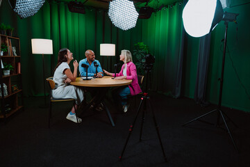Group of three diverse hosts having a podcast discussion