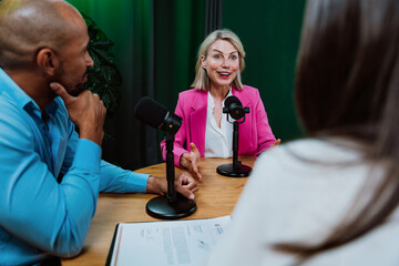 Group of three diverse hosts having a podcast discussion