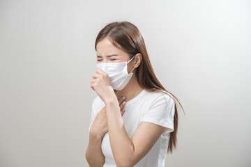Unhealthy sickness, unwell asian young woman wearing mask coughing, have sore throat, suffering symptom cough feeling bad and healthcare of air pollution and dust, PM2.5 isolated white background.