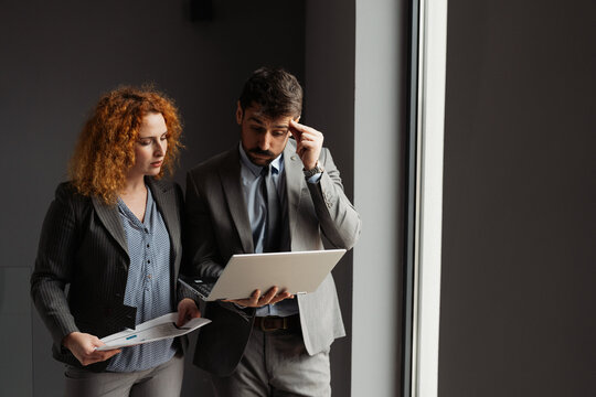 Businessman and businesswoman working together in a modern office, analyzing business data on a laptop.

 - Powered by Adobe