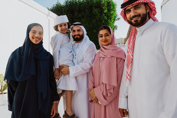 Emirati family standing together smiling in traditional attire