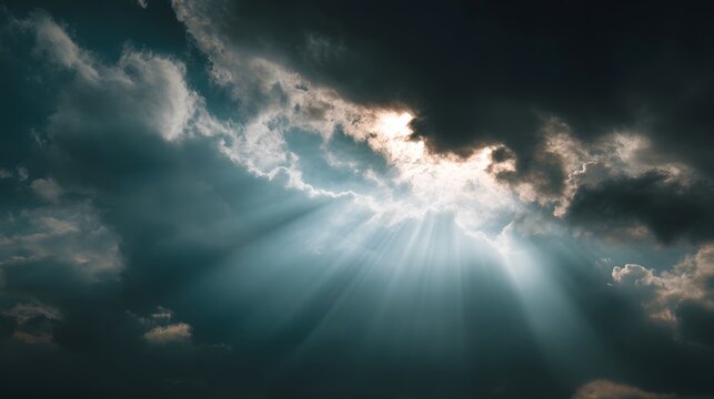 Intense sunbeams pierce through dark dramatic storm clouds overhead