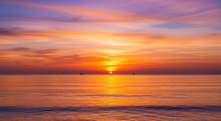 Fototapeta premium Vibrant Tropical Sunset Over Calm Ocean with Fiery Sky A breathtaking, low-horizon seascape captured during the peak of golden hour, showcasing a mesmerizing display of colors