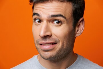 Obraz premium Man with a surprised expression against an orange background