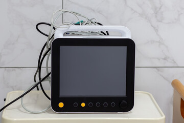 There is a heart monitor on the table. On a gray background.
