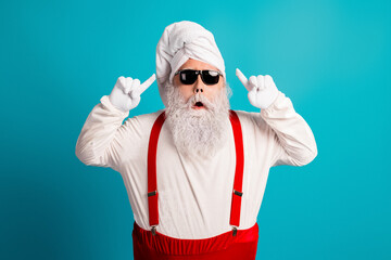 Santa look alike wearing red suspenders and white beard with turban and sunglasses posing for a festive winter holiday scene