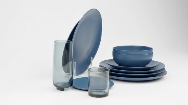 Matte blue dinnerware set against white background, with vase