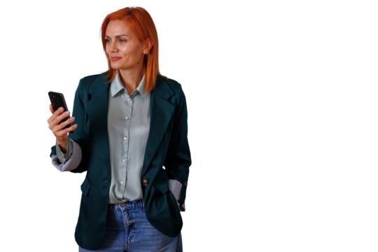 Woman with red hair holding smartphone, smiling and looking away, standing in business casual attire on transparent background