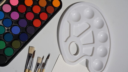 Palette of watercolors and brushes on a white background