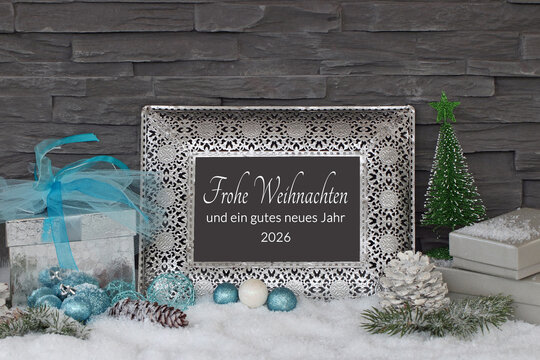 Winterliche Kulisse mit Geschenken und Weihnachtsschmuck im Schnee auf einem Rahmen steht der Text frohe Weihnachten und ein gutes neues Jahr. - Powered by Adobe