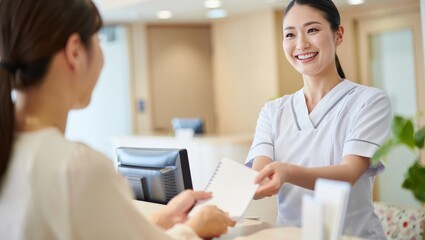 Obraz premium Smiling receptionist handing a notebook to a patient at a healthcare facility
