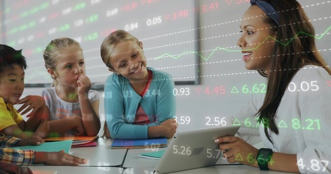 Leading teacher in white top explaining stock trends at classroom table, with tablet, copy space