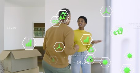 Sorting couple unpacking boxes in white room, with open box and hex overlays showing eco metrics