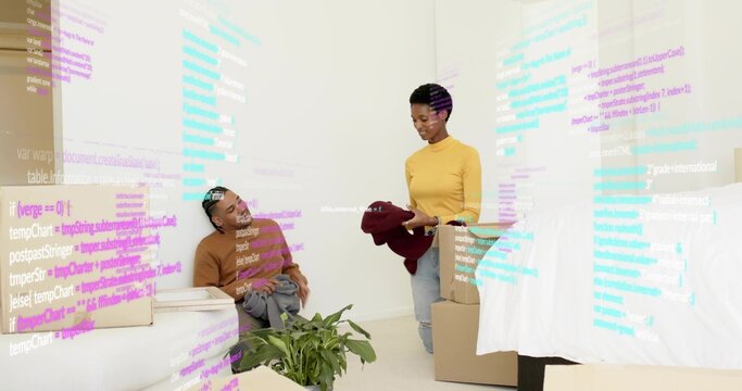Unpacking couple sorting clothes in residential bedroom, with moving boxes and projected code