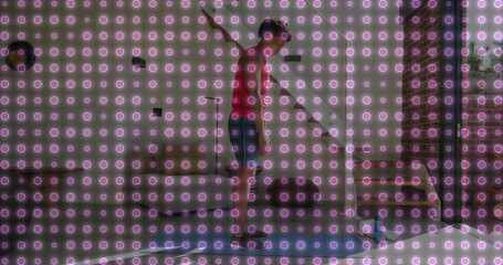 Balancing male teenager slacklining between brick pillars on patio in sneakers, banners overhead