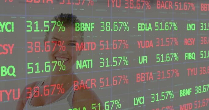 Smiling woman standing behind transparent display at trading floor, displaying tickers in red green