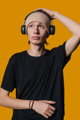young guy checks headphone sound levels, youthful individual adjusts beanie during recording session
