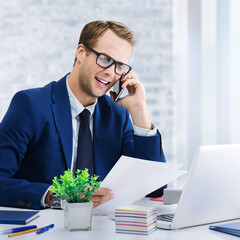Portrait of happy smiling confident businessman in glasses blue jacket working with cellphone and...