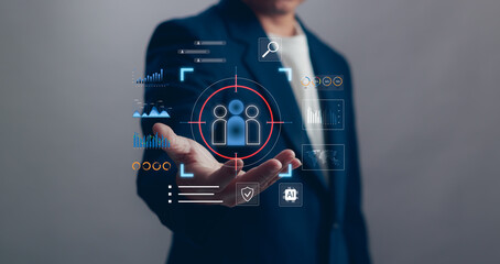 Businessman hold virtual interface with audience target, analytics and AI icon, representing customer targeting, data intelligence, CRM, digital marketing strategy and personalized business solution.