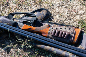 A hunting weapon lies in the dry grass before the start of the hunt.