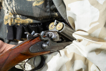 Close-up of a hunter's hand with a gun. Medium shot of a hunter with a weapon.