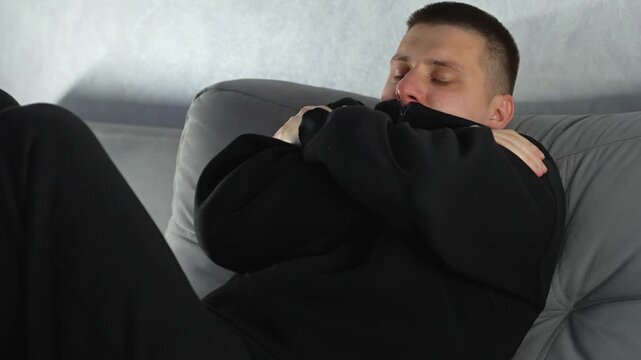 A man in a cold room is suffering from hypothermia.
The man is shivering and warming himself with his hands.
Frost, hypothermia, fever, winter