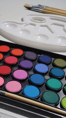 Colorful eye shadow palette with paintbrushes on white background