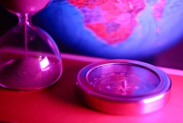 The hourglass and the compass and the globe symbols of time, travelling, distance, way concept photo 