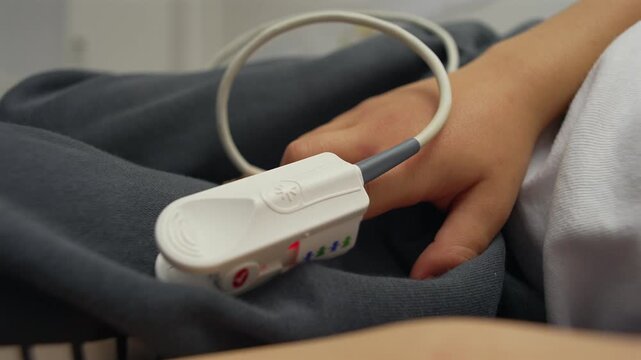 Close-up of child&rsquo;s hand with pulse oximeter sensor in hospital, detail of medical monitoring device measuring oxygen levels, healthcare technology and child treatment concept