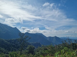Majestic Mountainscape: Capturing the vastness of nature, this scenic landscape showcases rolling mountains under a dynamic sky filled with fluffy clouds. Evoking feelings of awe and serenity.