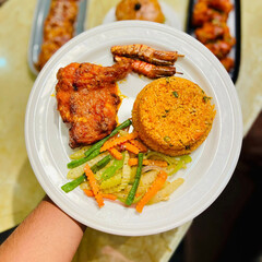 Delicious grilled chicken fillet with succulent shrimp and flavorful rice served with a fresh vegetable salad on a white plate