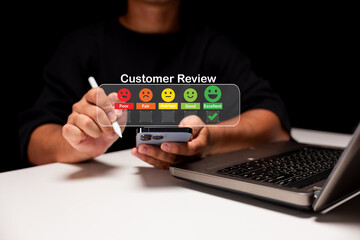 A person reviews a service using a smartphone, displaying satisfaction levels through emoticons, while a laptop sits nearby in a dark environment.