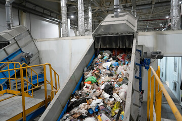 A conveyor belt with waste at a plant, waste moves along the belt to be sorted into fractions and collected for further processing.
