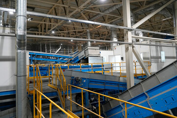 View of the conveyor and mechanical units for collecting and sorting at a large plant for processing household waste, an industrial view of modern ecology