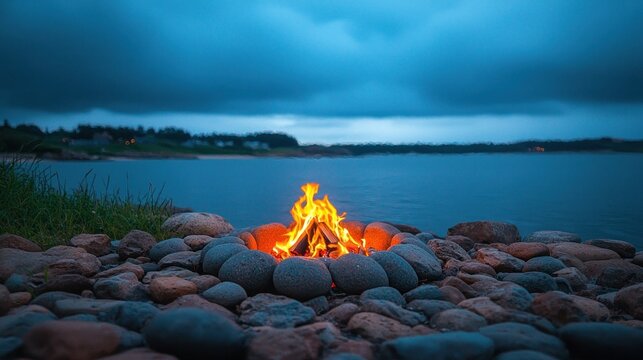 Lakeside campfire glows, ringed by smooth stones, under a moody, cloudy sky - Powered by Adobe