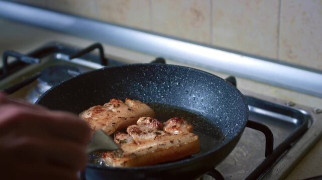 Close-up of pork frying in a pan for traditional Peruvian dish Pan con Chicharron. Street food preparation, authentic Latin American cuisine, sizzling meat cooking concept.