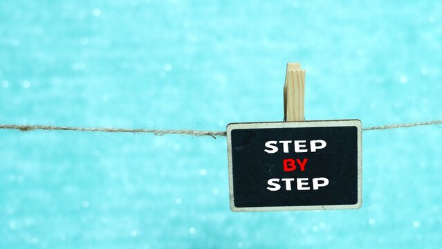 STEP BY STEP writing concept on a mini whiteboard.