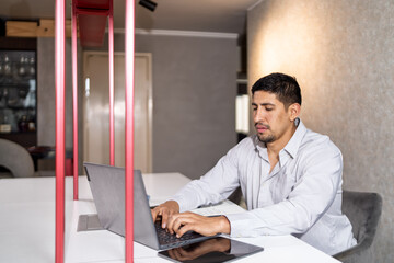Fototapeta premium Man typing on laptop in modern office space
