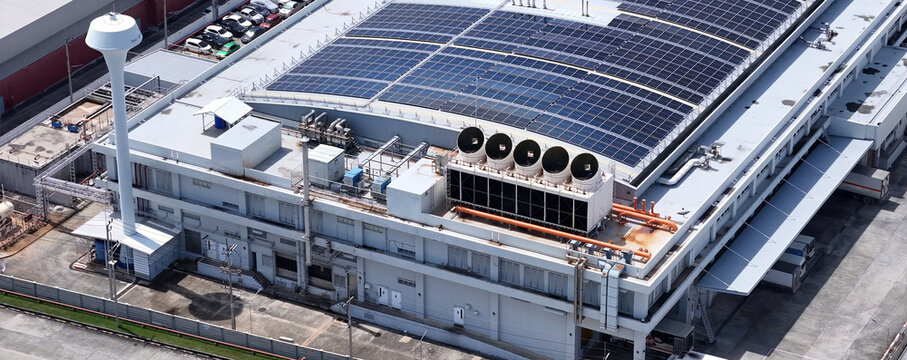 Cooling towers in data center building. Air conditioning cooling towers in front of building with fins to the front. Industrial cooling towers or air cooled water chillers with piping system.