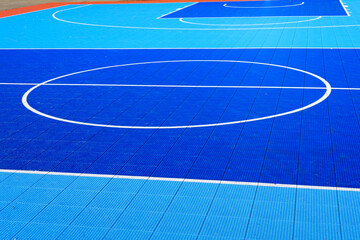 Blue plastic basketball court with white lines, detail of a basketball court