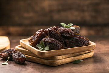 Dates in wooden bowl on rustic table, natural sweet dried fruit, healthy organic snack