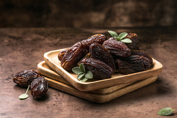 Dates in wooden bowl on rustic table, natural sweet dried fruit, healthy organic snack