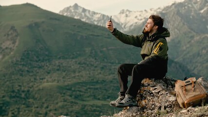 Traveler man taking photo on smartphone sitting on mountain top with copy space concept of freedom mindfulness adventure travel lifestyle happiness technology connection and inspiration - Powered by Adobe