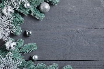 Flat lay composition with fir tree branches and other Christmas decor on grey wooden table, space...