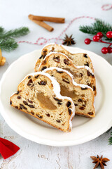 Traditional German Christmas stollen with marzipan, raisins and powdered sugar on a festive table. 