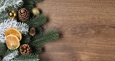 Flat lay composition with fir tree branches and Christmas decor on wooden table. Space for text