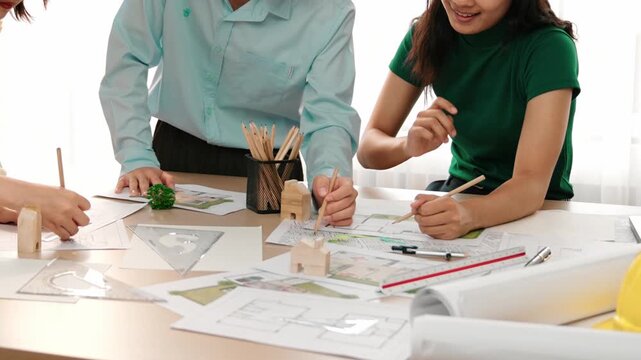 A video of architect use measurement tools and pencil to measure blueprint. Architect design house construction on a table at studio, with architectural plan scattered around. Focus hand. Delineation.